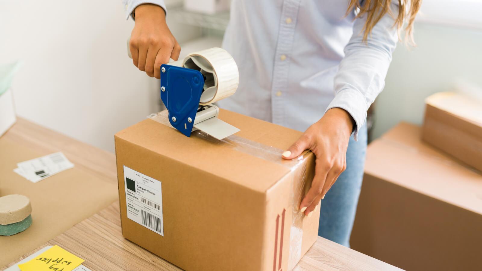 Mujer empaquetando caja para ser enviada