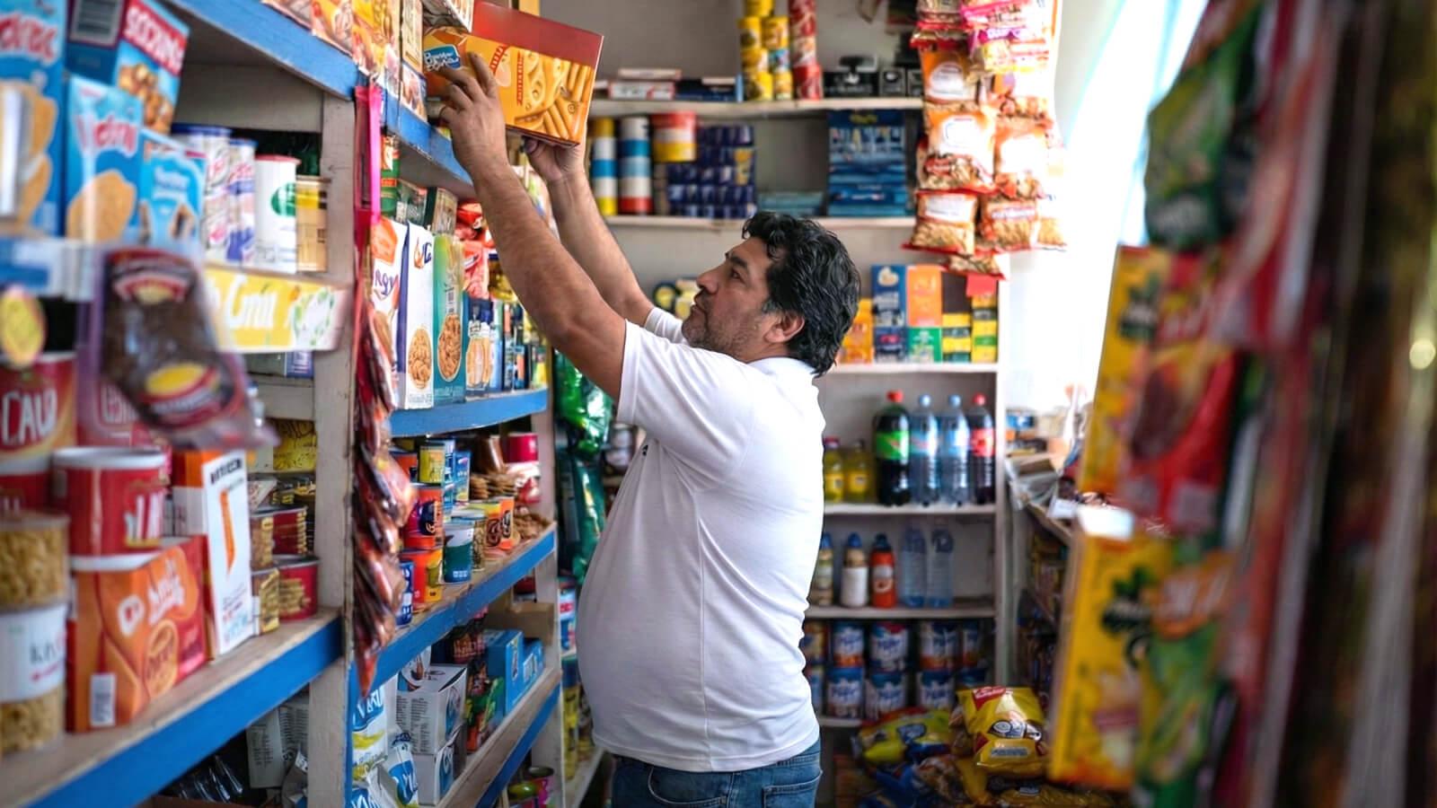 Hombre acomodando productos de consumo masivo en su tienda