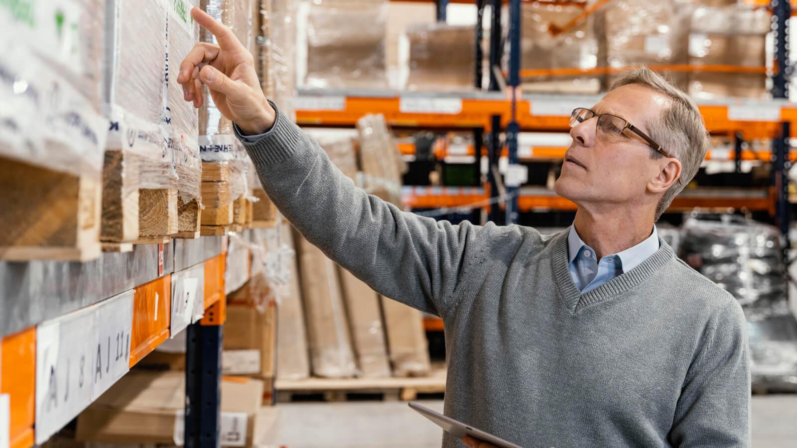 Hombre revisando paquetería en depósito