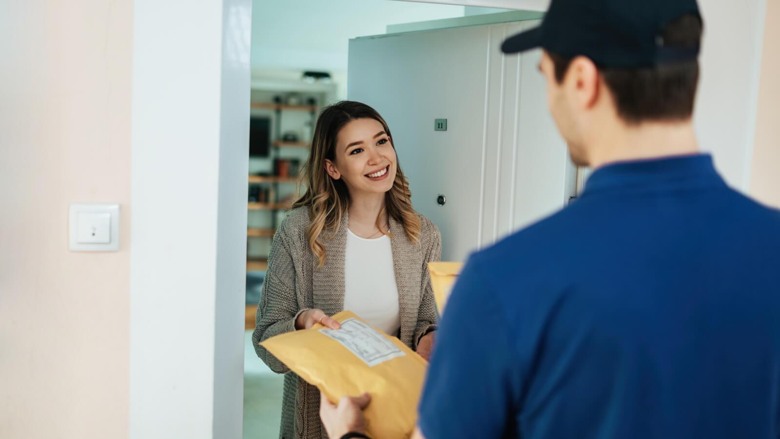 Mujer recibiendo su compra en su casa